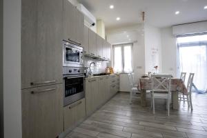 una cocina con armarios de madera y una mesa con comedor. en RESIDENZA IL ROCCOLO en San Fermo della Battaglia