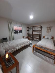 1 dormitorio con 2 camas y mesa con lámpara en Apart Fincas de San Pablo en Deán Funes