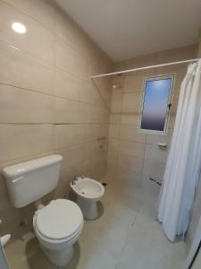 a bathroom with a toilet and a sink at Apart Fincas de San Pablo in Deán Funes