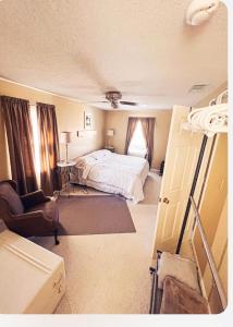 1 dormitorio con 1 cama y 1 silla en Rose Ellen’s Country Estate en Albany