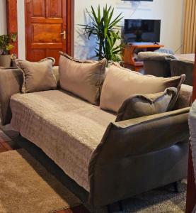 um sofá com almofadas na sala de estar em Casă de vacanță Chalet le Cristal em Sovata