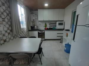 eine Küche mit einem Tisch und Stühlen sowie einem Kühlschrank in der Unterkunft Apartamento com três suítes em Garanhuns próximo ao Parque Euclides Dourado in Garanhuns