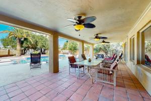 a patio with a table and chairs and a pool at Pink Bloom Sanctuary in Scottsdale