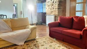 - un salon avec deux chaises et un canapé rouge dans l'établissement 7 bedrooms villa with private pool enclosed garden and wifi at Povoa de Lanhoso, à Póvoa de Lanhoso