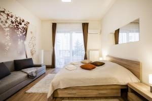 un dormitorio con una cama y un sofá en Downtown charm with balcony and garden view, en Budapest