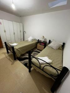 2 Einzelbetten in einem Zimmer mit in der Unterkunft Angelina Pilar Córdoba in Pilar