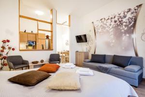 una sala de estar con una cama y un sofá en Downtown charm with balcony and garden view, en Budapest