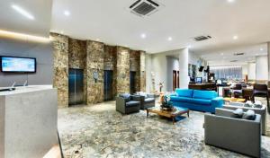 a living room with blue couches and a lobby at Natal Plaza in Natal