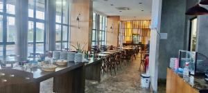 a restaurant with long tables and chairs and windows at Natal Plaza in Natal