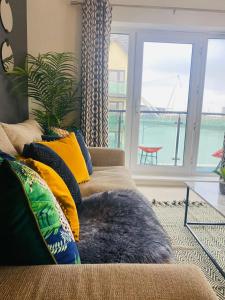 sala de estar con sofá y almohada grande en Luxury 2 Bedroom waterfront apartment with balcony en Newport