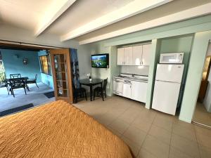 a room with a bed and a kitchen with a table at Vista Grande Resort - A Gay Men's Resort in Palm Springs