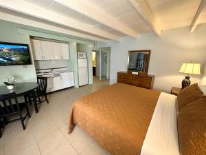 a bedroom with a bed and a table and a kitchen at Vista Grande Resort - A Gay Men's Resort in Palm Springs