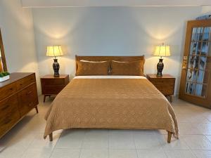 a bedroom with a bed with two night stands and two lamps at Vista Grande Resort - A Gay Men's Resort in Palm Springs