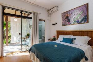 a bedroom with a bed and a sliding glass door at Ondas da Grande Spa Cama e Café, Praia Grande, Penha, Santa Catarina in Penha