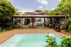 una casa con una hamaca en el patio en Ondas da Grande Spa Cama e Café, Praia Grande, Penha, Santa Catarina, en Penha