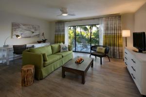 a living room with a green couch and a table at La Siesta Resort & Villas in Islamorada