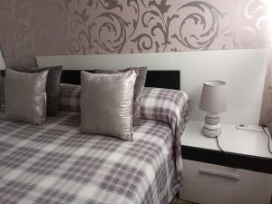 a bedroom with a bed with a plaid blanket and a lamp at Piso amplio de 3 habitaciones, 2 baños, ascensor y parking in Burriana
