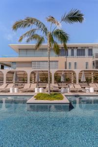 una piscina con una palmera frente a un edificio en InterContinental Sorrento Mornington Peninsula en Sorrento