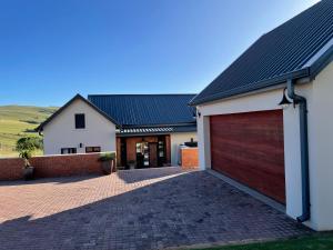 a house with a garage and a brick driveway at Highland Gate Eagles Breeze in Dullstroom +3 photos