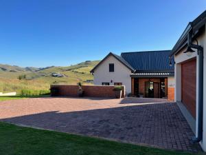 a house with a brick driveway and a garage at Highland Gate Eagles Breeze in Dullstroom
