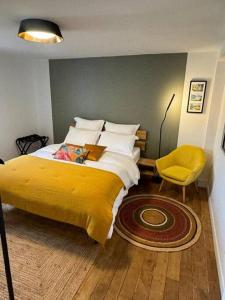 um quarto com uma cama grande e um cobertor amarelo em L'esKale / Gare de Tours em Tours