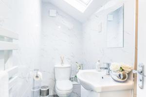 Baño blanco con aseo y lavamanos en Luxury Hideaway, City Centre,Parking,Netflix Sleeps 3 en Coventry