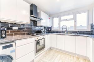 a kitchen with white cabinets and a sink at Luxury Hideaway, City Centre,Parking,Netflix Sleeps 3 in Coventry