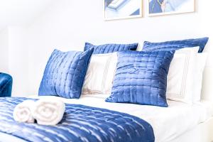 1 cama azul y blanca con almohadas azules en Luxury Hideaway, City Centre,Parking,Netflix Sleeps 3 en Coventry