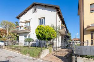 uma casa branca com uma cerca à frente. em VillaPino 27 - New Apartment Como em Lucino