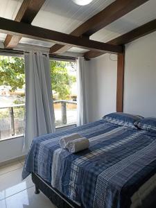 a bedroom with a bed with a blue plaid blanket at Pousada Portal da Mucugê in Porto Seguro