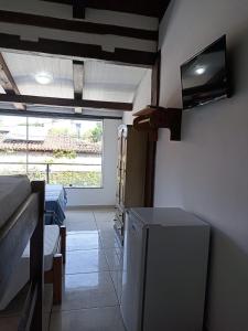 a room with a bed and a television on the wall at Pousada Portal da Mucugê in Porto Seguro