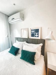 1 dormitorio con 1 cama con almohadas verdes y blancas en Studio Novissimo Perto do Copacabana Palace, en Río de Janeiro