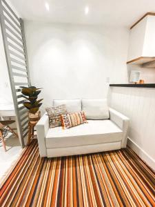 a white couch sitting on a rug in a living room at Studio Novissimo Perto do Copacabana Palace in Rio de Janeiro