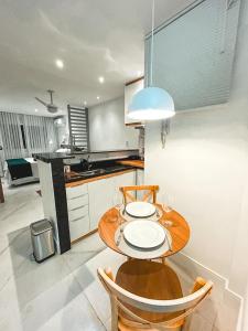 uma cozinha com uma mesa de madeira e cadeiras numa cozinha em Studio Novissimo Perto do Copacabana Palace no Rio de Janeiro