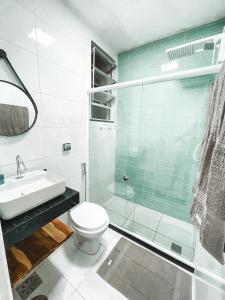 La salle de bains est pourvue de toilettes et d'une douche en verre. dans l'établissement Studio Novissimo Perto do Copacabana Palace, à Rio de Janeiro