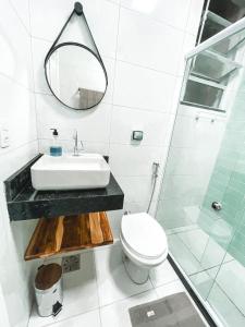 La salle de bains est pourvue d'un lavabo, de toilettes et d'un miroir. dans l'établissement Studio Novissimo Perto do Copacabana Palace, à Rio de Janeiro