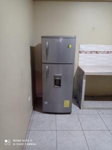 um pequeno frigorífico sentado no canto de um quarto em El Amanecer 2.0 em Abancay
