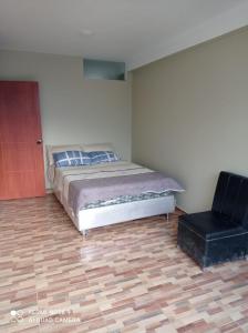 1 dormitorio con 1 cama y 1 silla en El Amanecer 2.0, en Abancay