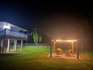 a gazebo with chairs and lights in a yard at night at Rancho Alegre. Bring your boat and RV too! in Clewiston