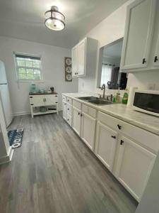 a kitchen with white cabinets and a wooden floor at Rancho Alegre. Bring your boat and RV too! in Clewiston