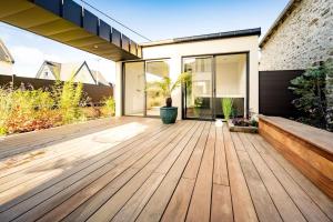 an open patio with a wooden deck at HOLEN in Langueux