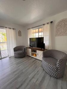 ein Wohnzimmer mit 2 Stühlen und einem Flachbild-TV in der Unterkunft Rancho Alegre. Bring your boat and RV too! in Clewiston