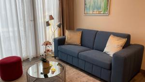 uma sala de estar com um sofá azul e uma mesa em Cozy apartment with terrace, SJ Cosmopolitan Tower em San José