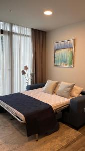 een slaapkamer met een groot bed voor een raam bij Cozy apartment with terrace, SJ Cosmopolitan Tower in San José