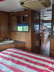 a bedroom with a bed and a sink in a room at 'Arvey the American RV in Haxey