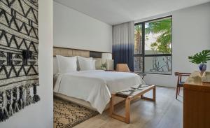 a bedroom with a bed and a desk and a window at Four Seasons Resort Los Cabos in La Ribera