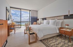 a bedroom with a large bed with a desk and a desk at Four Seasons Resort Los Cabos in La Ribera