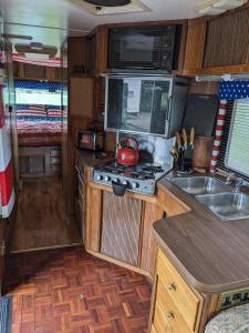 a kitchen in an rv with a tea kettle on the stove at 'Arvey the American RV in Haxey