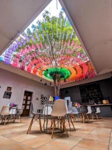 a room with tables and chairs and a large colorful ceiling at BKL Hotel in Oaxaca City