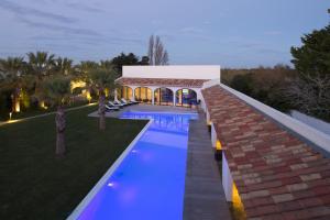 a swimming pool in a yard with a building at Mangio Fango Hotel et Spa in Saintes-Maries-de-la-Mer